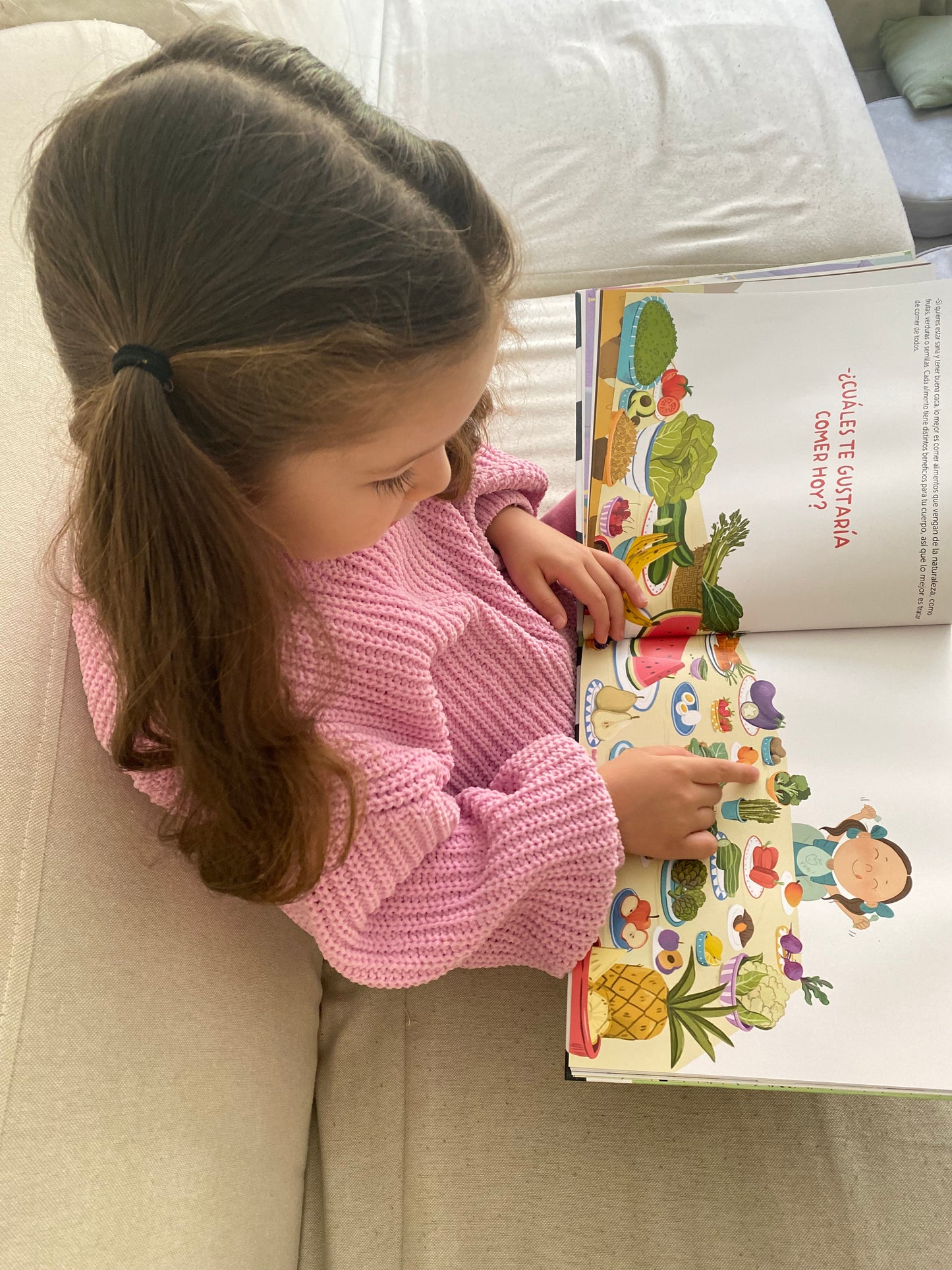 Niña leyendo libro "Mira tu caca"